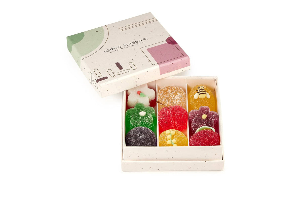 Scatola da 9 gelatine di frutta assortite Iginio Massari, in eleganti colori naturali e forme ispirate a fiori e frutti.